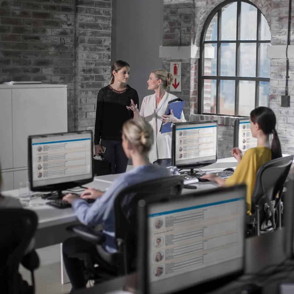 Office training session with diverse employees and computers in a modern workspace.